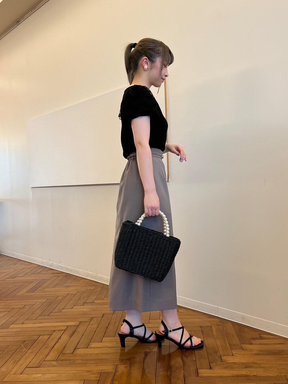 ブラック系のTシャツ/カットソー、ブラウン系のスカート、ブラック系のハンドバッグを着用したレディースの春コーディネートの2枚目の写真