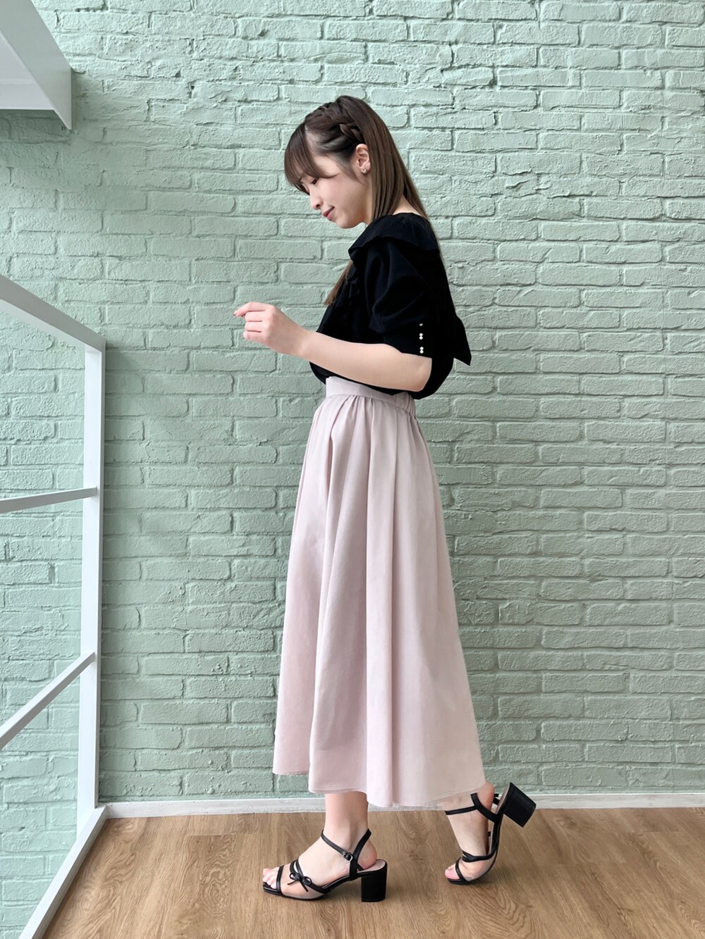 ブラック系のニット/セーター、グレー系のスカートを着用したレディースの春コーディネートの2枚目の写真