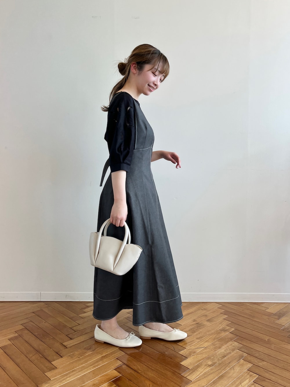 ブラック系のスカート、ブラック系のTシャツ/カットソー、ホワイト系のショルダーバッグを着用したレディースの春コーディネートの2枚目の写真