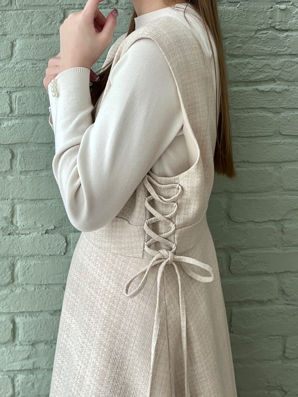 ベージュ系のテーラードジャケット、ベージュ系のワンピース、ホワイト系のニット/セーターを着用したレディースの春コーディネートの4枚目の写真