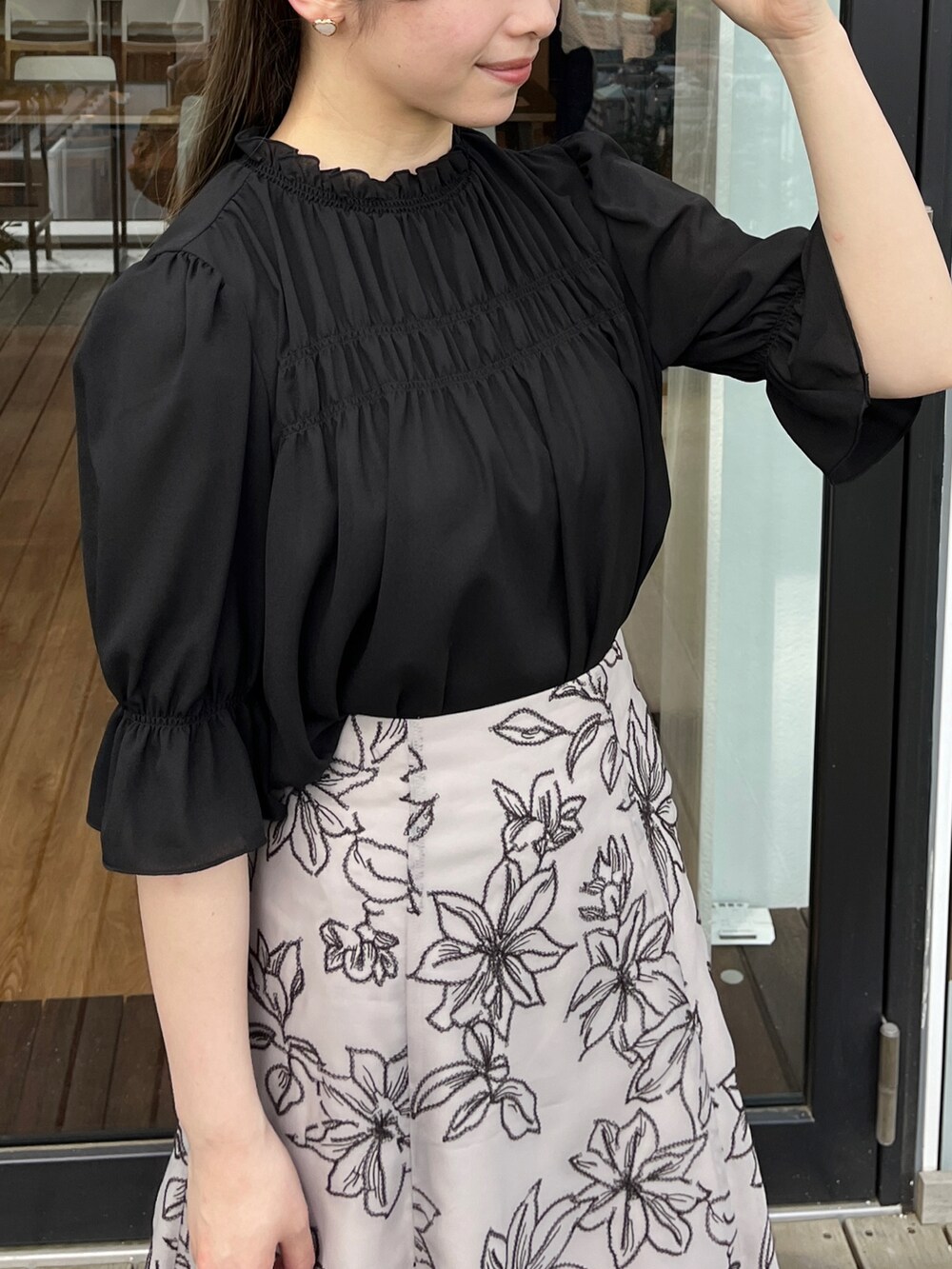 ブラウン系のスカート、ブラック系のシャツ/ブラウスを着用したレディースの夏コーディネートの3枚目の写真