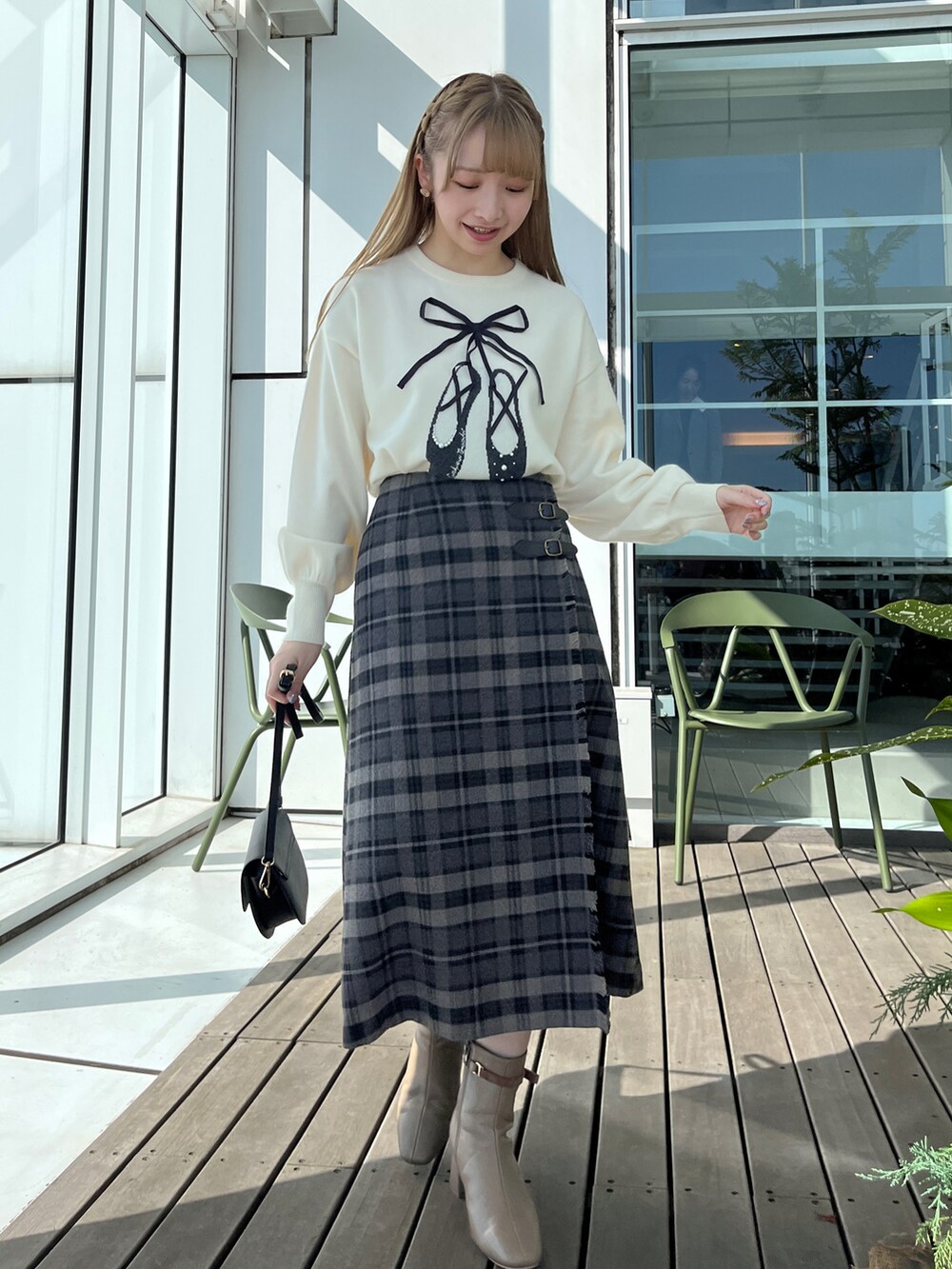 ブラック系のダウンジャケット/コート、ホワイト系のニット/セーター、グレー系のスカートを着用したレディースの秋コーディネートの4枚目の写真