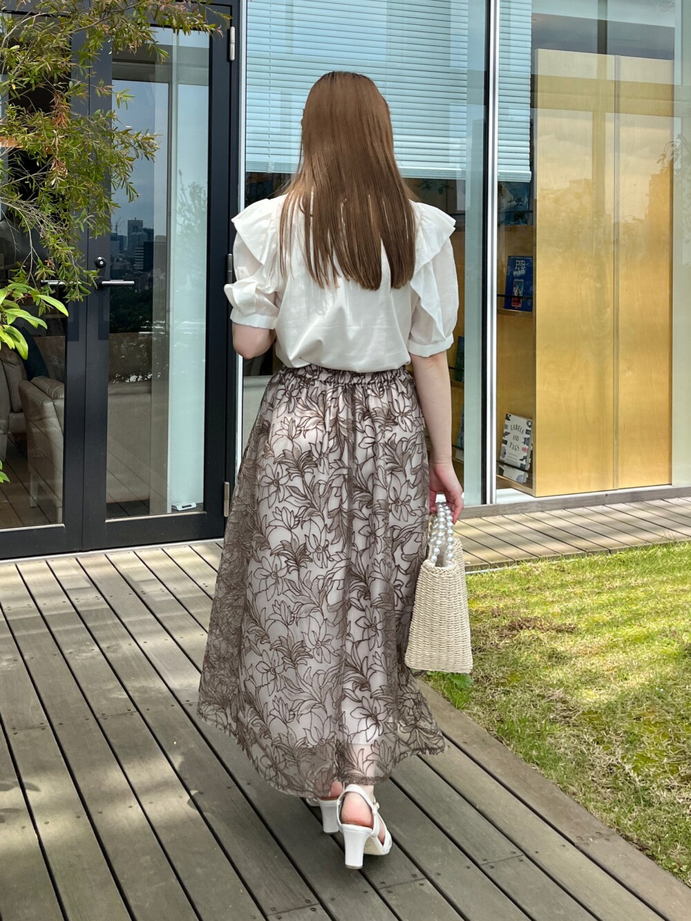 ホワイト系のTシャツ/カットソー、ブラウン系のスカート、ベージュ系のハンドバッグを着用したレディースの夏コーディネートの3枚目の写真