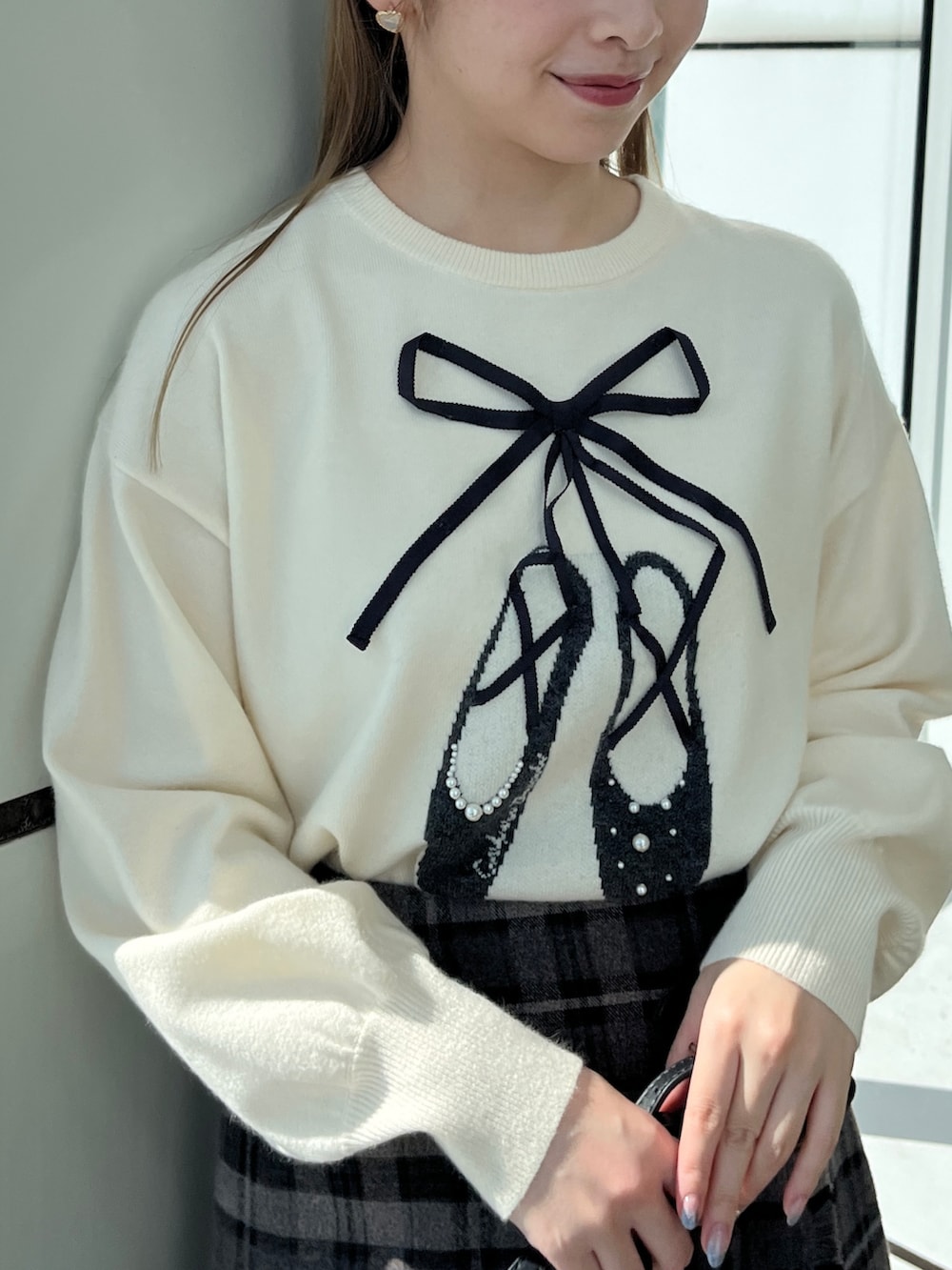 グレー系のスカート、ホワイト系のニット/セーター、ブラック系のショルダーバッグを着用したレディースの秋コーディネートの3枚目の写真