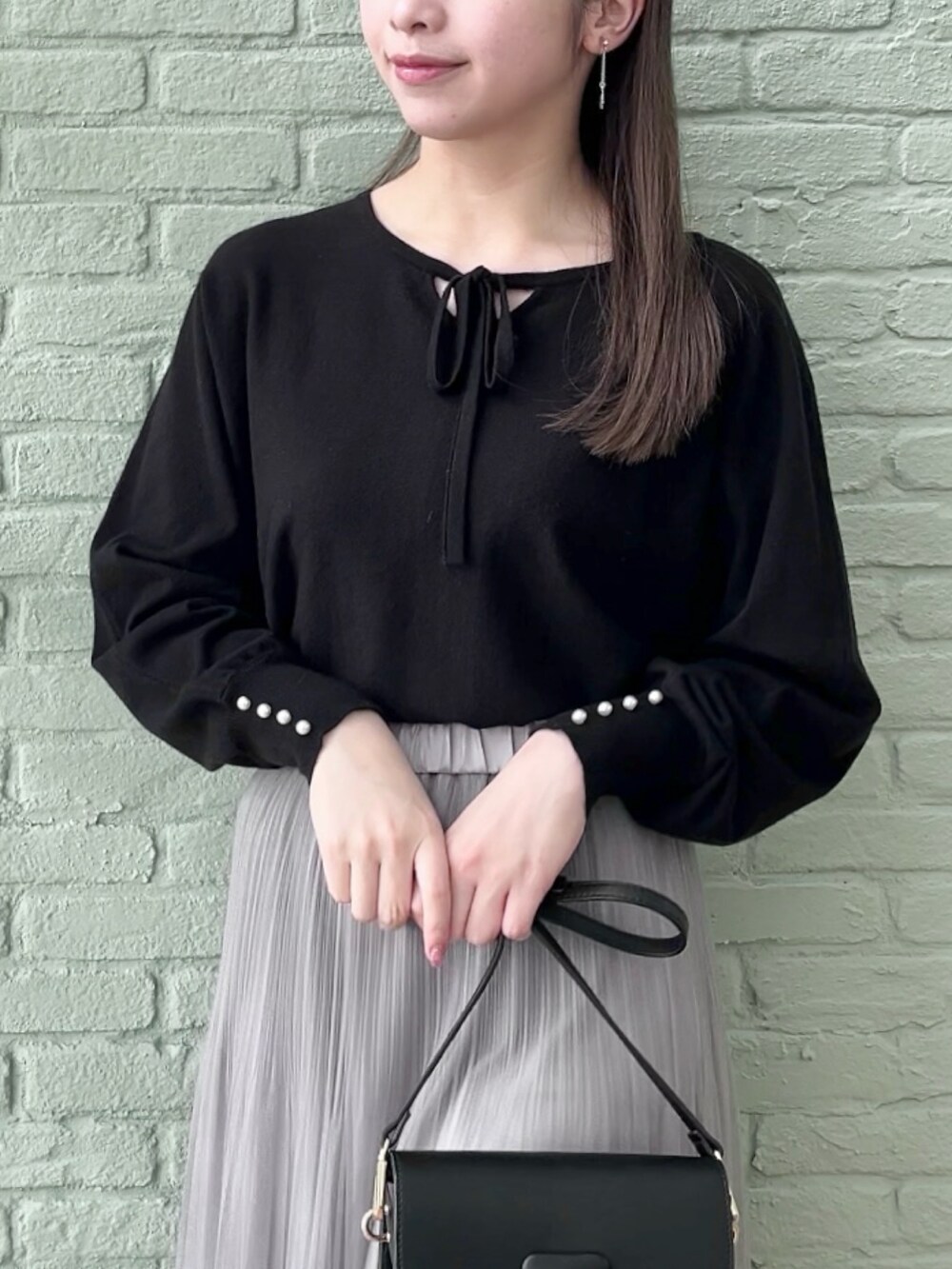 グレー系のスカート、ブラック系のニット/セーターを着用したレディースの秋コーディネートの4枚目の写真