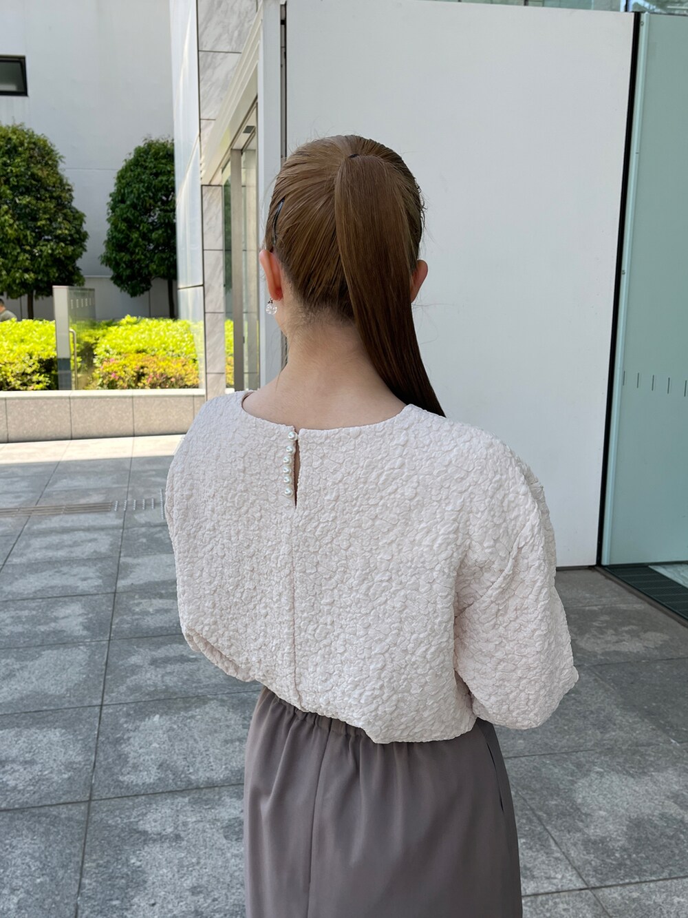 ホワイト系のTシャツ/カットソー、ブラウン系のスカート、グレー系のショルダーバッグを着用したレディースの夏コーディネートの4枚目の写真