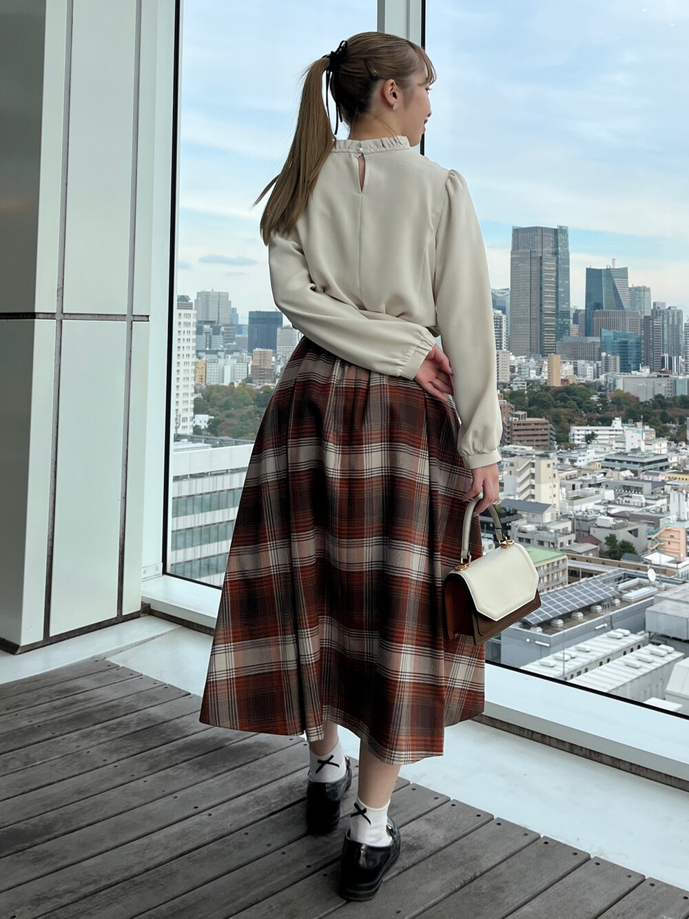 ホワイト系のシャツ/ブラウス、ブラウン系のスカート、ホワイト系のショルダーバッグを着用したレディースの秋コーディネートの2枚目の写真