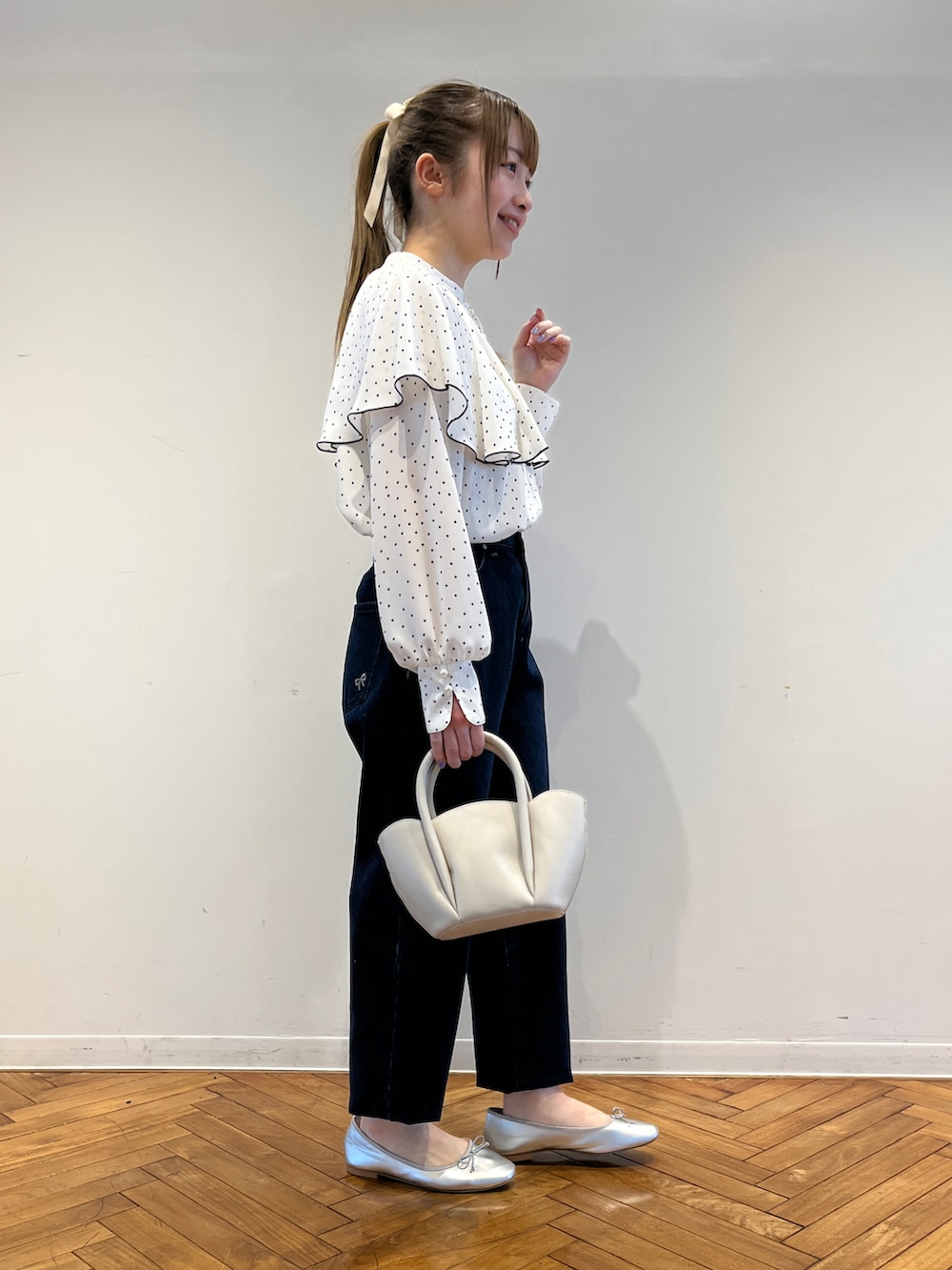 ホワイト系のシャツ/ブラウス、ブルー系のデニムパンツ、ホワイト系のショルダーバッグを着用したレディースの春コーディネートの2枚目の写真