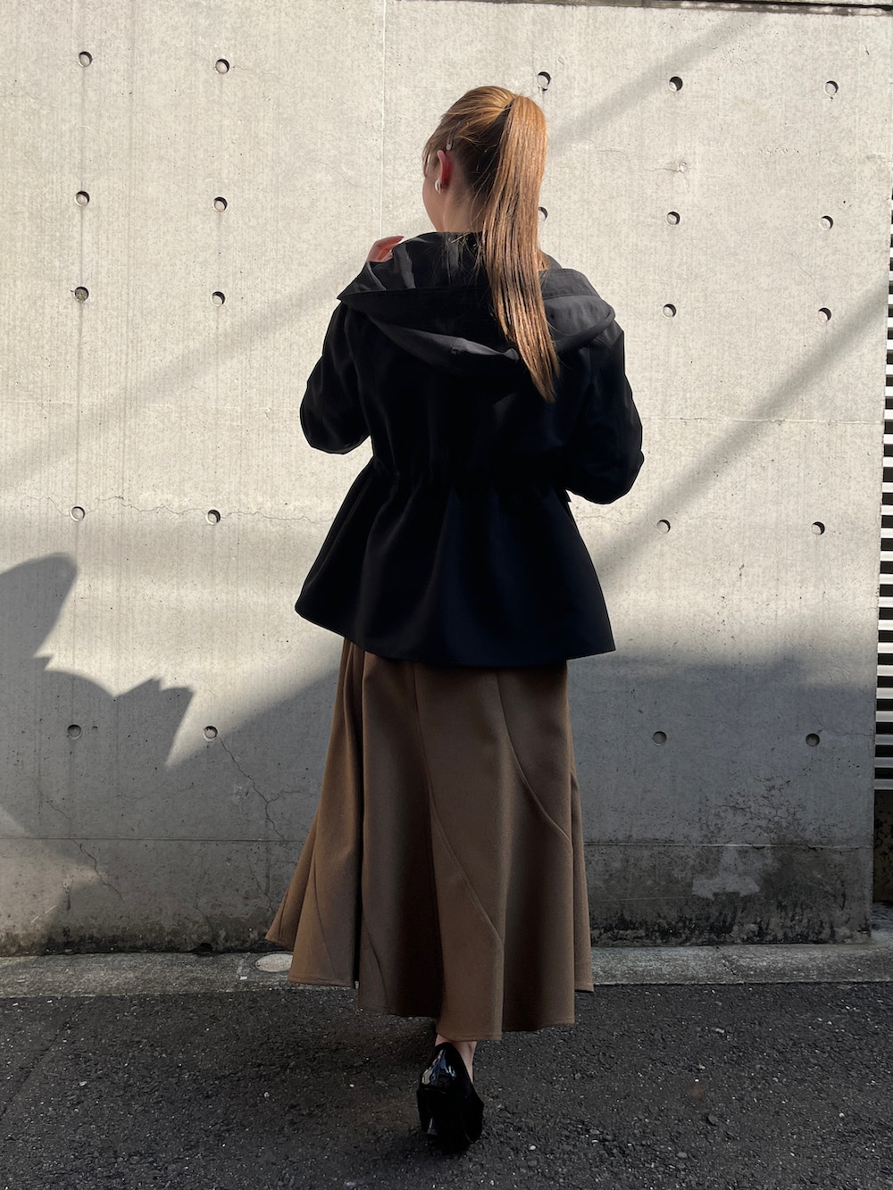 ホワイト系のシャツ/ブラウス、ブラック系のブルゾン、イエロー系のスカートを着用したレディースの秋コーディネートの3枚目の写真