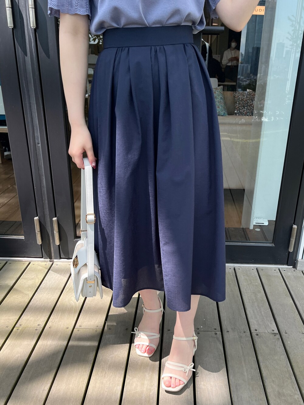 ブルー系のカーディガン/ボレロ、ブルー系のニット/セーター、ブルー系のスカートを着用したレディースの春コーディネートの5枚目の写真