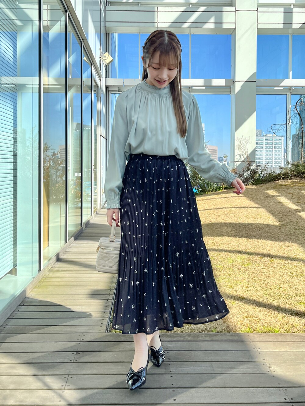 グレー系のトレンチコート、グリーン系のシャツ/ブラウス、ブラック系のスカートを着用したレディースの冬コーディネートの5枚目の写真