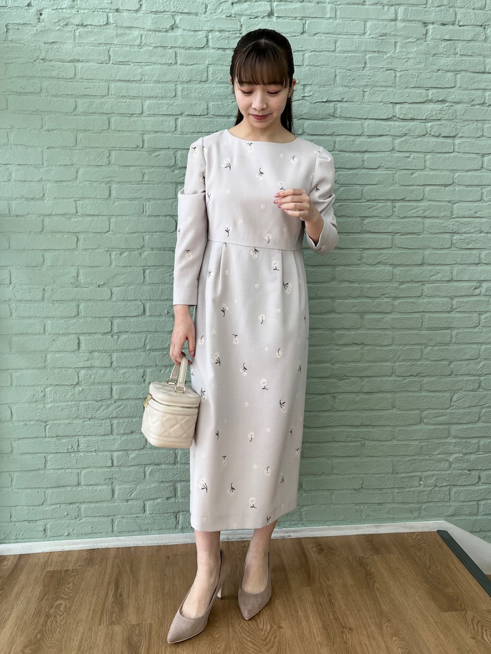 ベージュ系のパンプス、ピンク系のカーディガン/ボレロ、グレー系のワンピースを着用したレディースの冬コーディネートの4枚目の写真