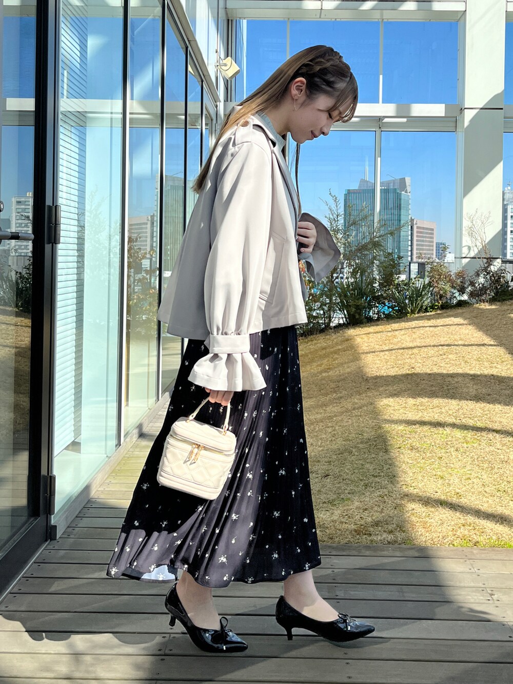 グレー系のトレンチコート、グリーン系のシャツ/ブラウス、ブラック系のスカートを着用したレディースの冬コーディネートの2枚目の写真