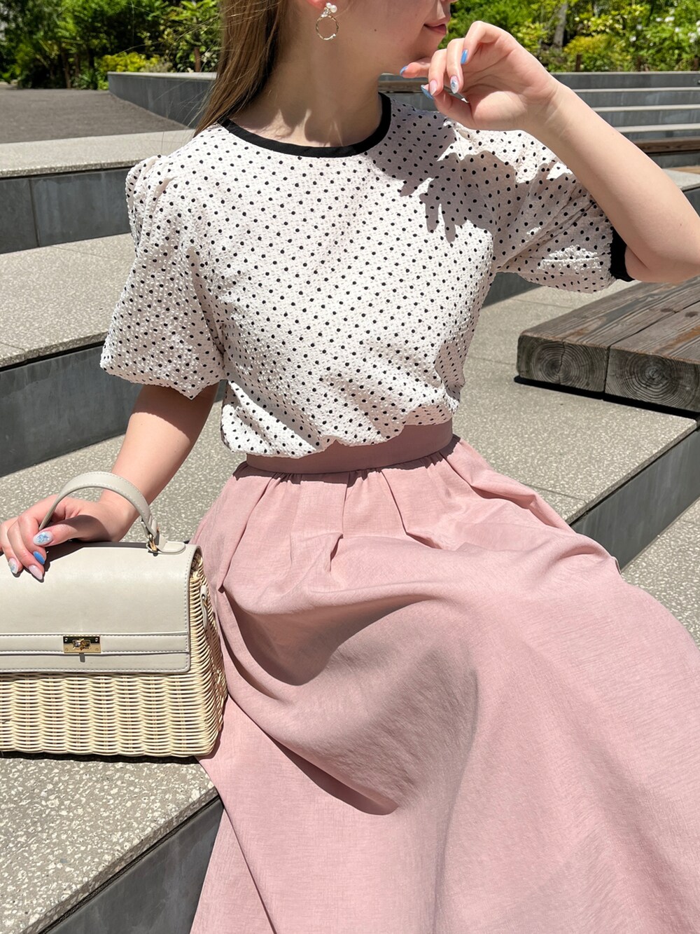 ベージュ系のシャツ/ブラウス、ピンク系のスカート、グレー系のショルダーバッグを着用したレディースの春コーディネートの2枚目の写真