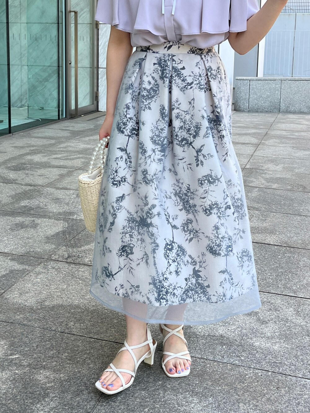 グレー系のシャツ/ブラウス、ベージュ系のハンドバッグ、ホワイト系のサンダルを着用したレディースの夏コーディネートの5枚目の写真