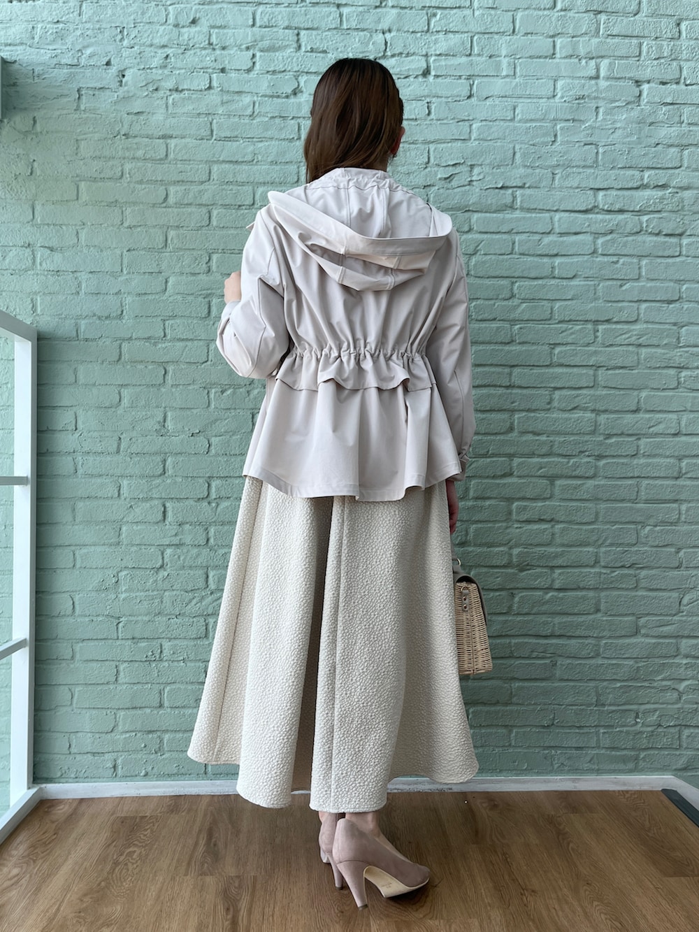 ベージュ系のスカート、ホワイト系のニット/セーター、グレー系のブルゾンを着用したレディースの春コーディネートの3枚目の写真