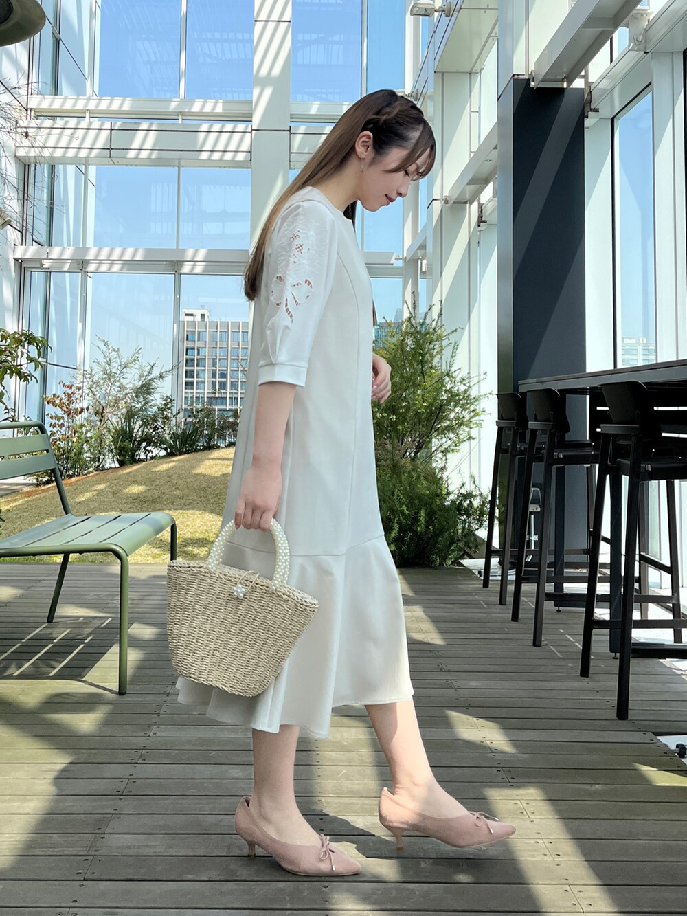 グレー系のワンピース、ホワイト系のTシャツ/カットソーを着用したレディースの春コーディネートの2枚目の写真