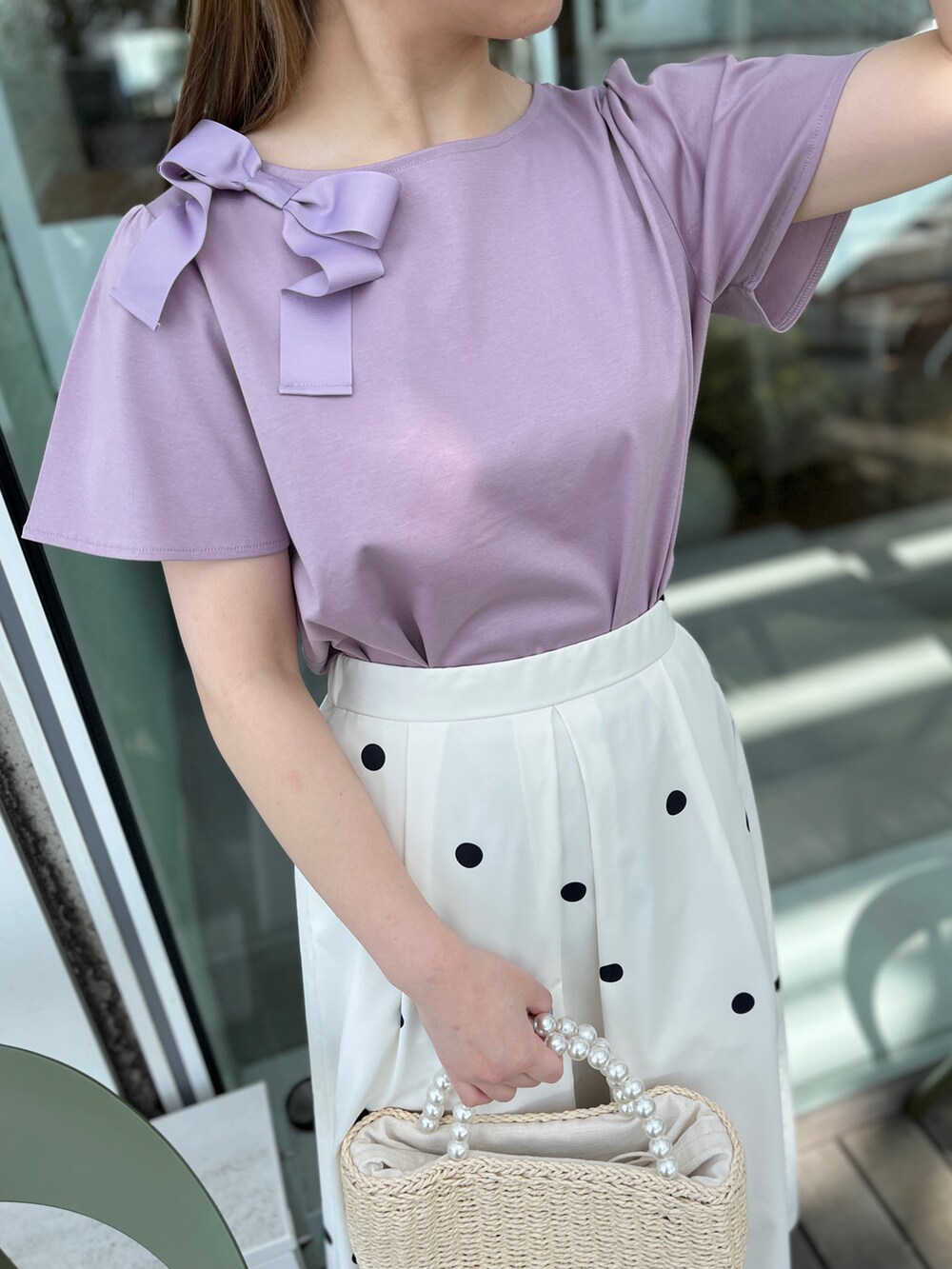 パープル系のTシャツ/カットソー、ベージュ系のハンドバッグ、ホワイト系のサンダルを着用したレディースの春コーディネートの4枚目の写真