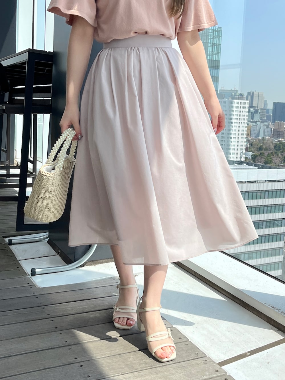 ピンク系のニット/セーター、グレー系のスカートを着用したレディースの春コーディネートの5枚目の写真