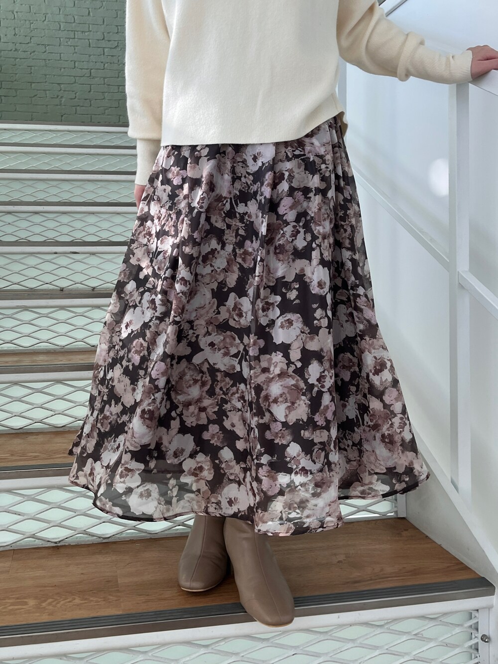 ホワイト系のニット/セーター、ブラウン系のスカート、ブラウン系のブーツを着用したレディースの秋コーディネートの4枚目の写真