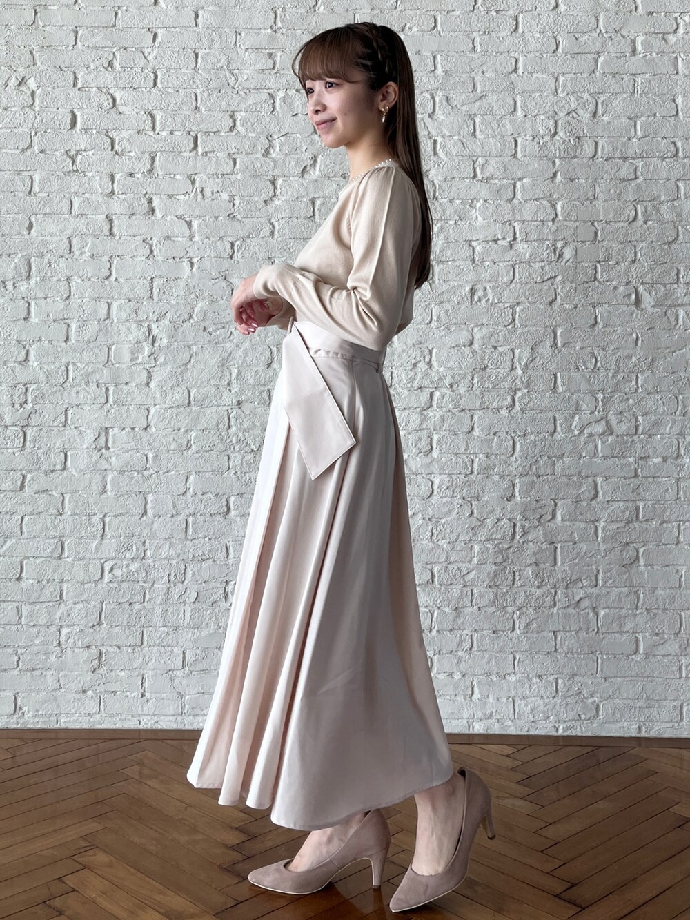 ホワイト系のニット/セーター、ホワイト系のスカート、ベージュ系のパンプスを着用したレディースの冬コーディネートの2枚目の写真