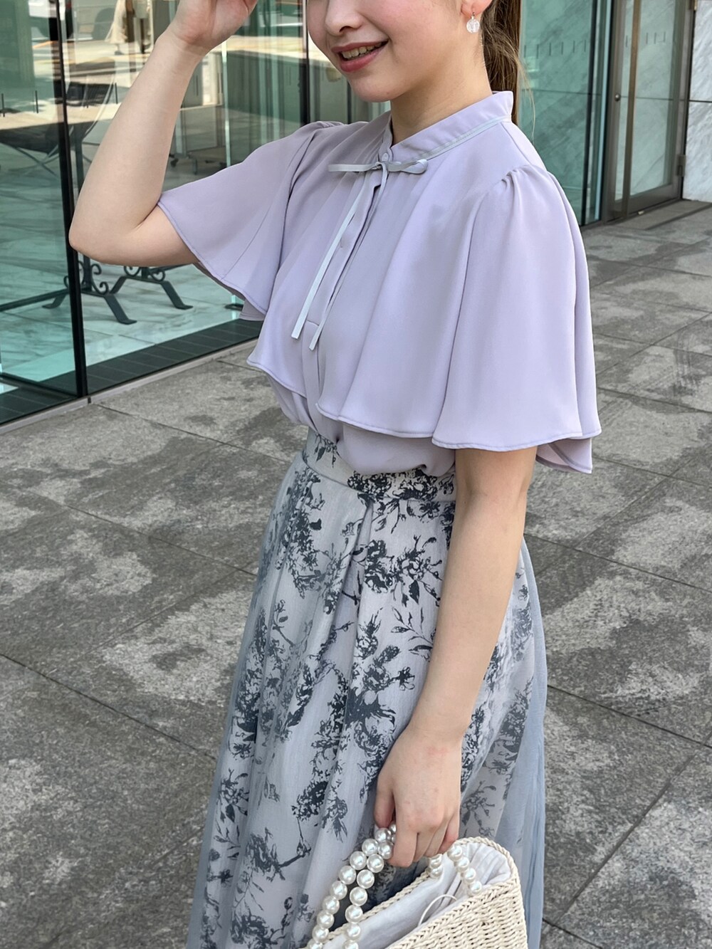 グレー系のシャツ/ブラウス、ベージュ系のハンドバッグ、ホワイト系のサンダルを着用したレディースの夏コーディネートの4枚目の写真