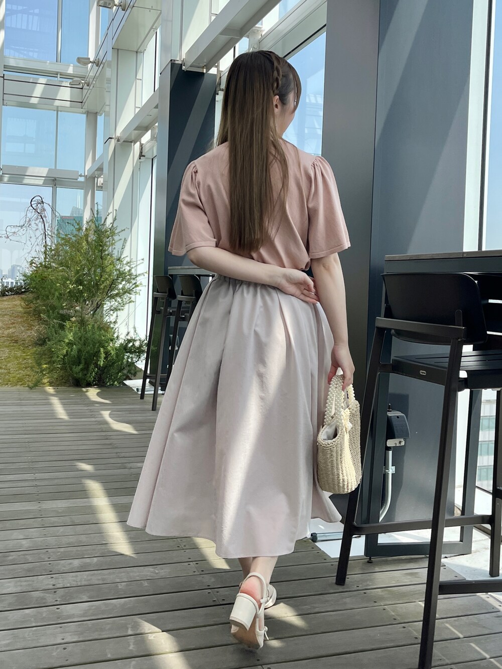 ピンク系のニット/セーター、グレー系のスカートを着用したレディースの春コーディネートの3枚目の写真