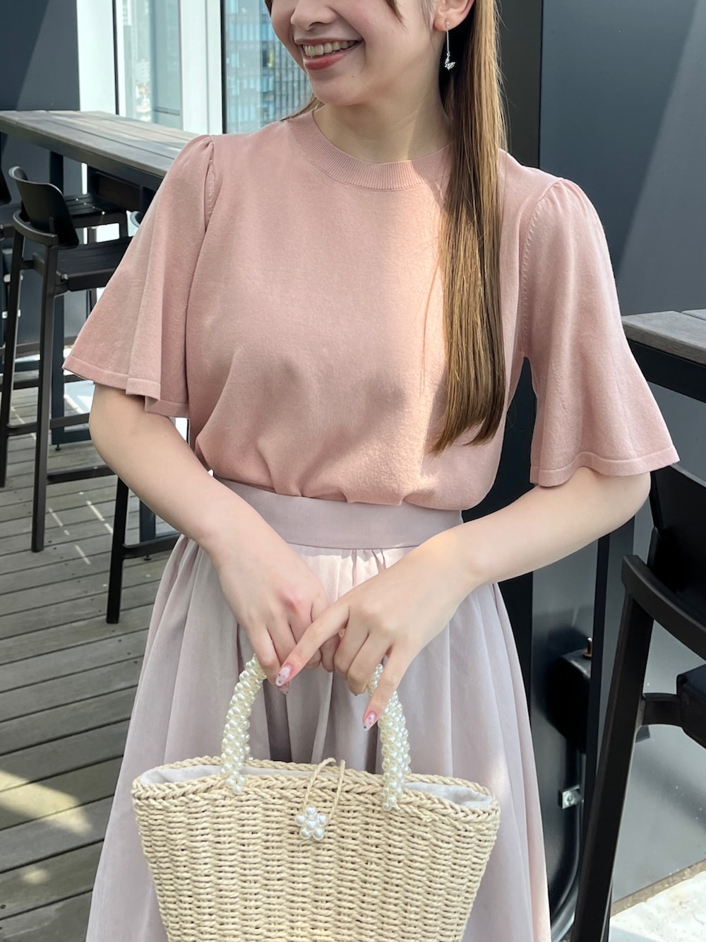 ピンク系のニット/セーター、グレー系のスカートを着用したレディースの春コーディネートの4枚目の写真