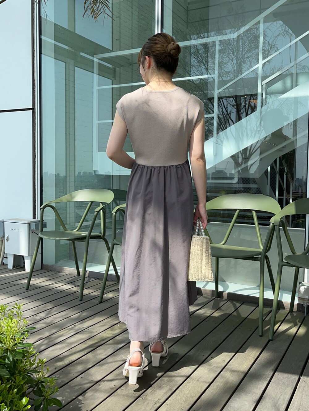 ブラウン系のワンピース、ベージュ系のハンドバッグ、ホワイト系のサンダルを着用したレディースの春コーディネートの3枚目の写真