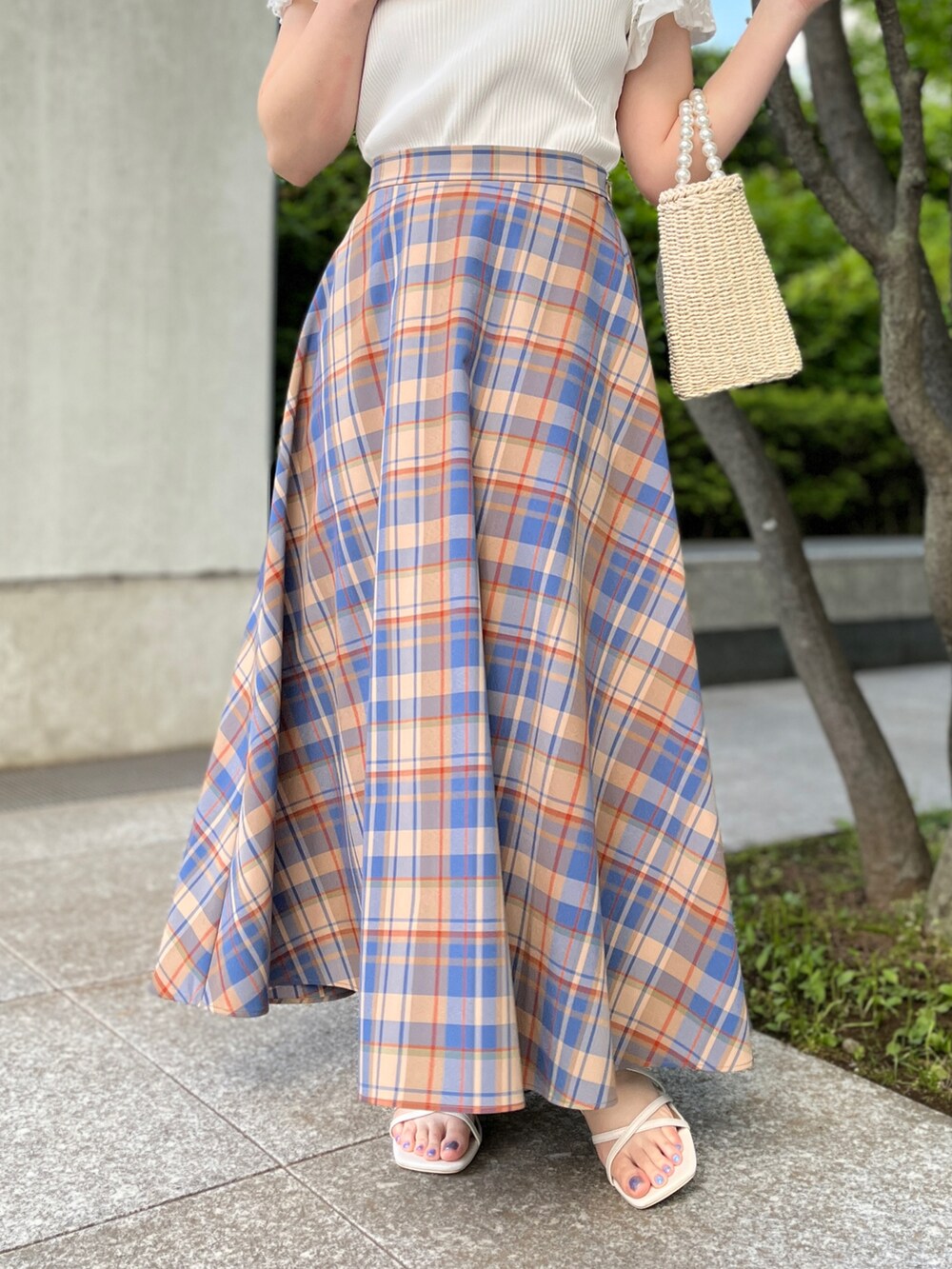 ホワイト系のTシャツ/カットソー、ベージュ系のハンドバッグ、ホワイト系のサンダルを着用したレディースの春コーディネートの5枚目の写真