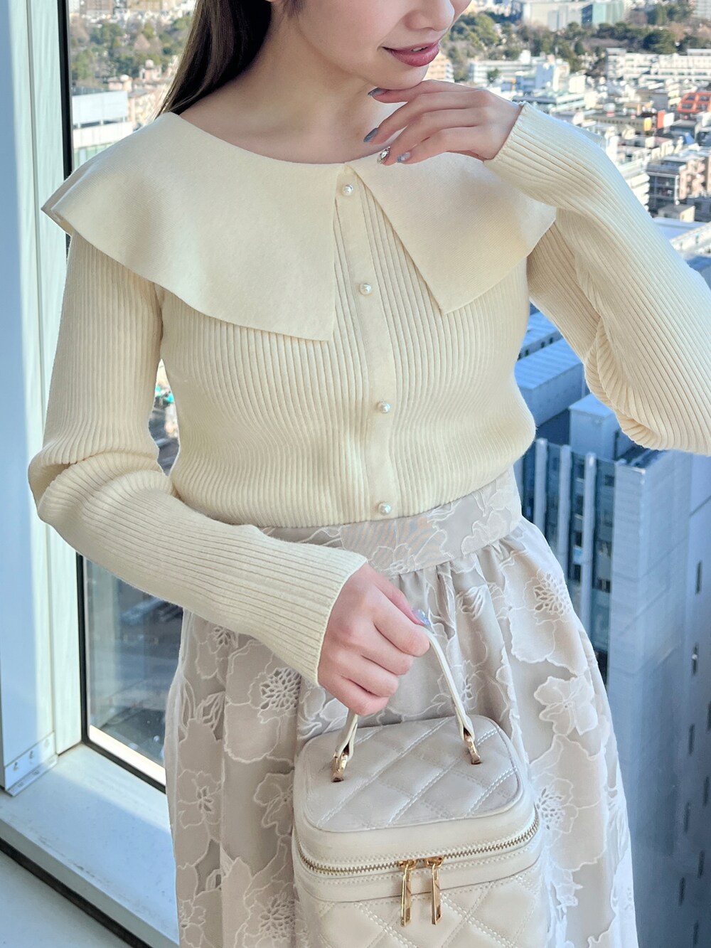 ベージュ系のブルゾン、ホワイト系のニット/セーター、ベージュ系のスカートを着用したレディースの冬コーディネートの5枚目の写真