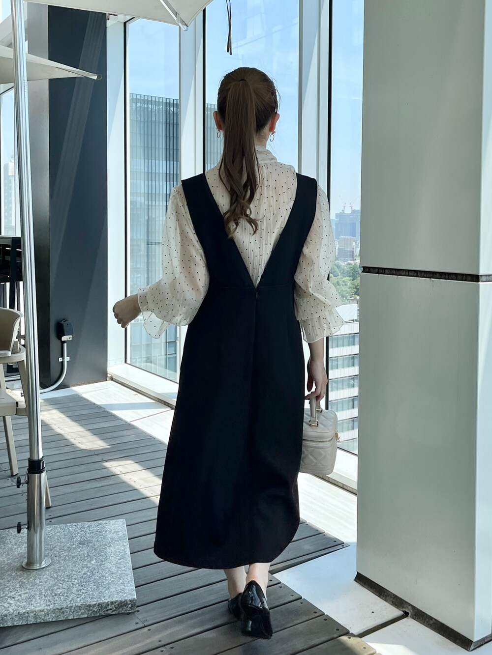 ホワイト系のショルダーバッグ、ベージュ系のワンピースを着用したレディースの秋コーディネートの3枚目の写真