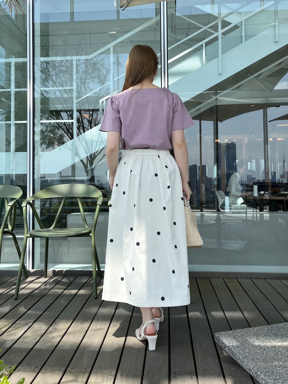 パープル系のTシャツ/カットソー、ベージュ系のハンドバッグ、ホワイト系のサンダルを着用したレディースの春コーディネートの3枚目の写真