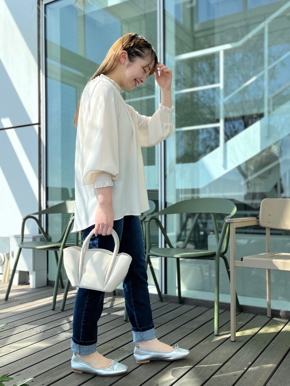 ブルー系のデニムパンツ、ホワイト系のシャツ/ブラウス、シルバー系のパンプスを着用したレディースの春コーディネートの2枚目の写真