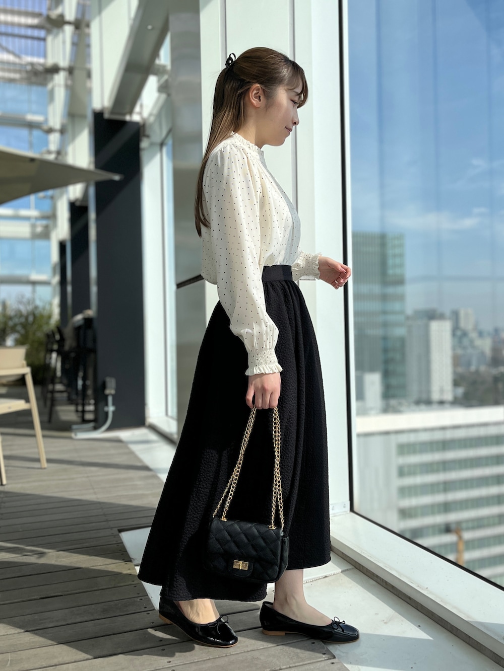 ホワイト系のシャツ/ブラウス、ブラック系のスカート、ブラック系のショルダーバッグを着用したレディースの冬コーディネートの2枚目の写真