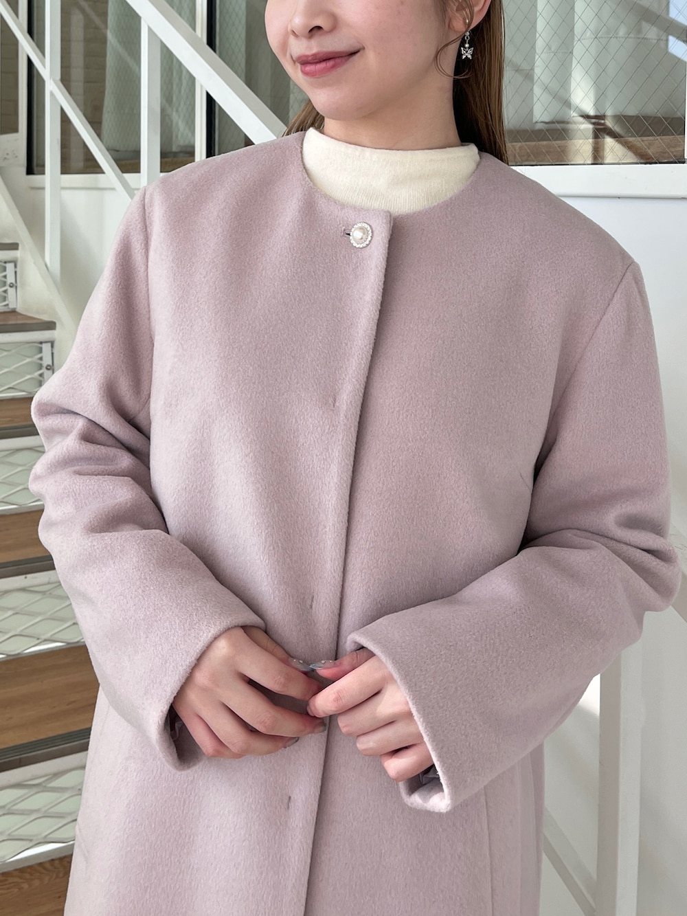 ブラウン系のスカート、ブラウン系のブーツ、ホワイト系のニット/セーターを着用したレディースの冬コーディネートの3枚目の写真