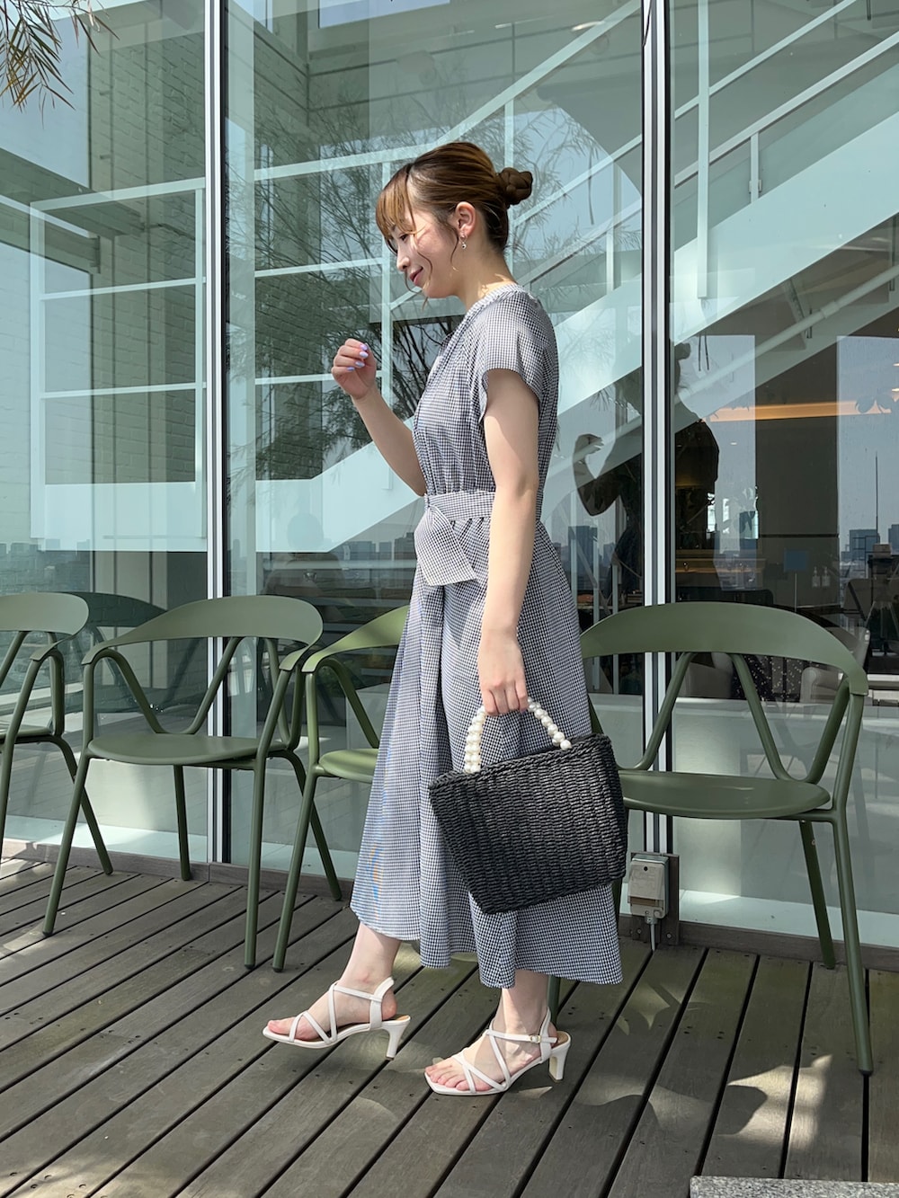 ブラック系のワンピース、ブラック系のハンドバッグ、ホワイト系のサンダルを着用したレディースの春コーディネートの2枚目の写真