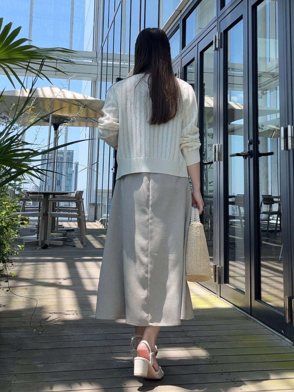 ホワイト系のカーディガン/ボレロ、ベージュ系のワンピースを着用したレディースの夏コーディネートの2枚目の写真