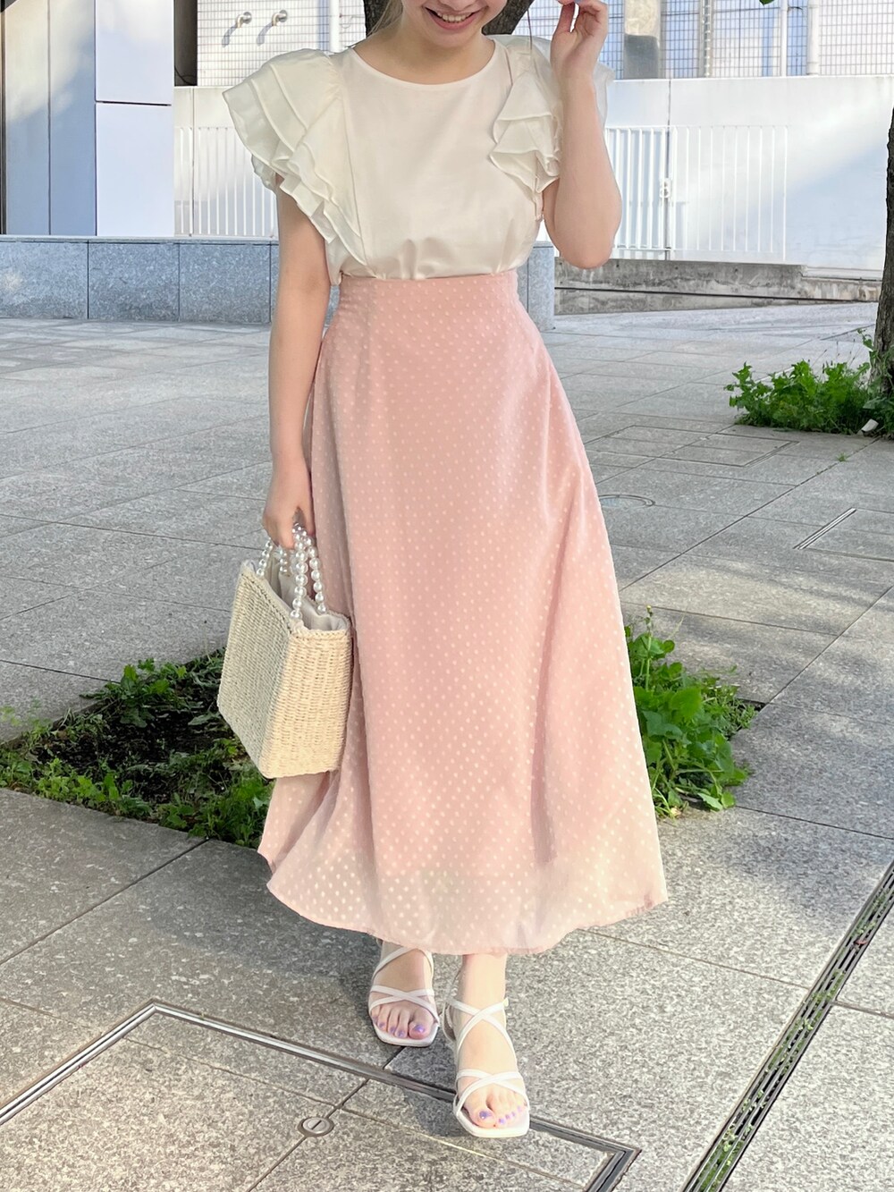 ホワイト系のTシャツ/カットソー、ピンク系のスカート、ベージュ系のハンドバッグを着用したレディースの春コーディネートの2枚目の写真