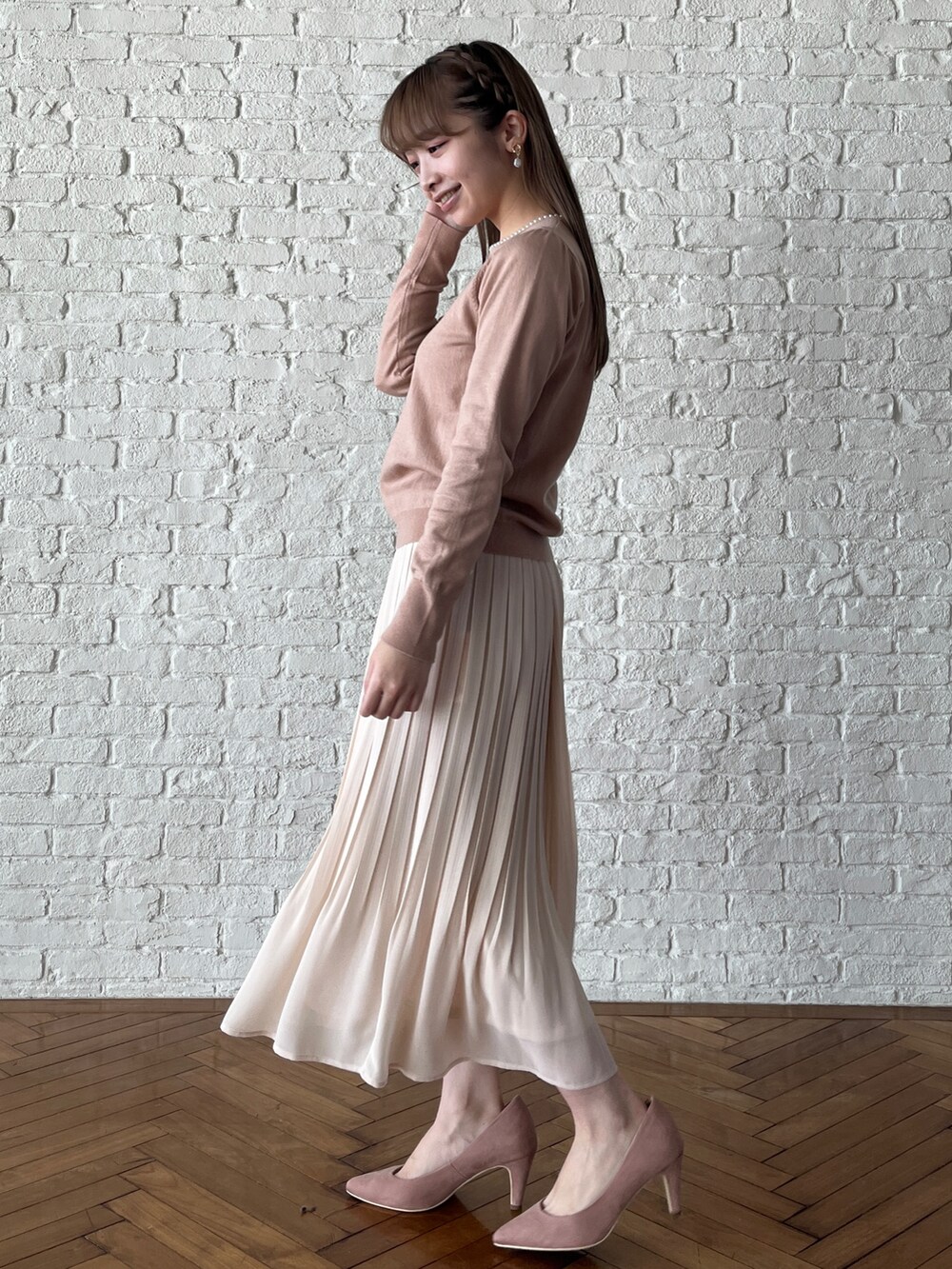 ピンク系のパンプス、ホワイト系のスカート、ピンク系のニット/セーターを着用したレディースの冬コーディネートの2枚目の写真