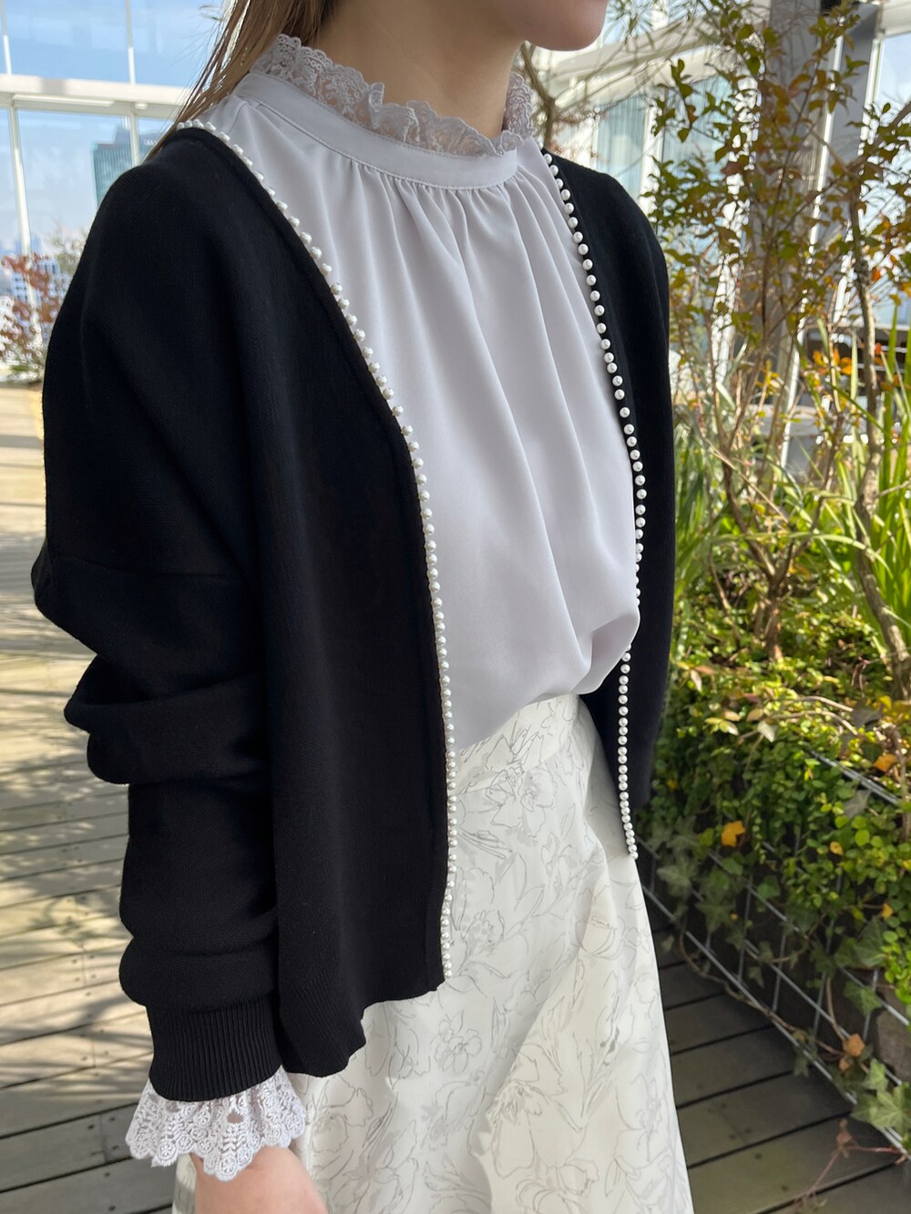 ブラック系のカーディガン/ボレロ、グレー系のシャツ/ブラウス、ベージュ系のスカートを着用したレディースの冬コーディネートの4枚目の写真