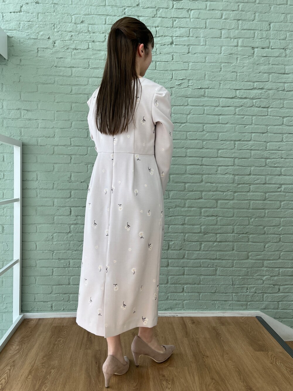 グレー系のワンピース、ベージュ系のパンプス、ホワイト系のショルダーバッグを着用したレディースの冬コーディネートの5枚目の写真