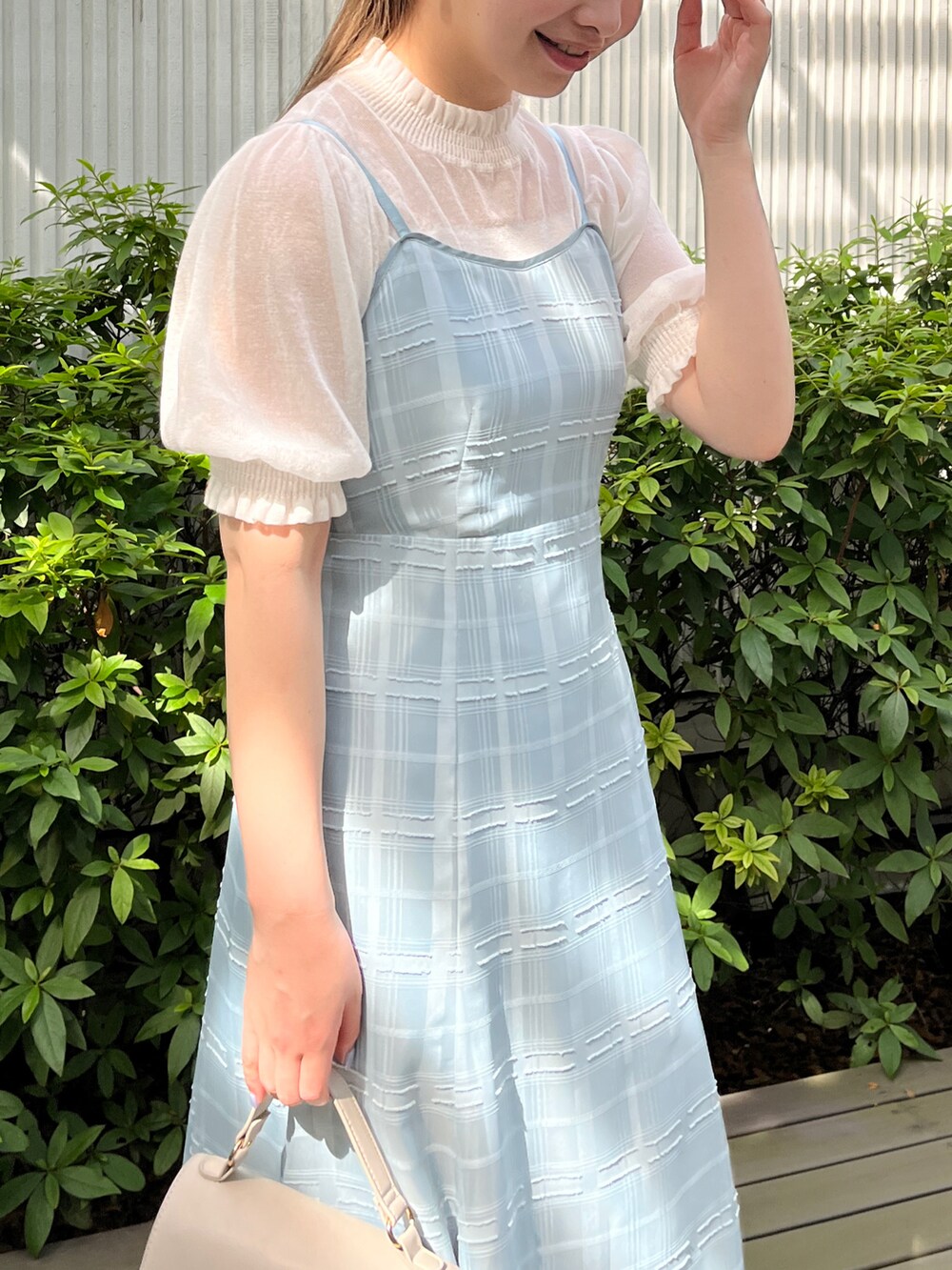 グリーン系のワンピース、ホワイト系のニット/セーター、グレー系のショルダーバッグを着用したレディースの夏コーディネートの4枚目の写真