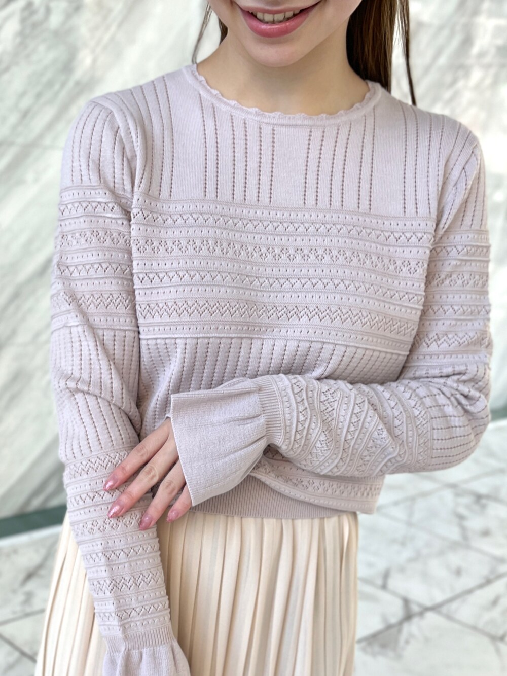 ピンク系のニット/セーター、ホワイト系のスカート、ホワイト系のパンプスを着用したレディースの冬コーディネートの4枚目の写真