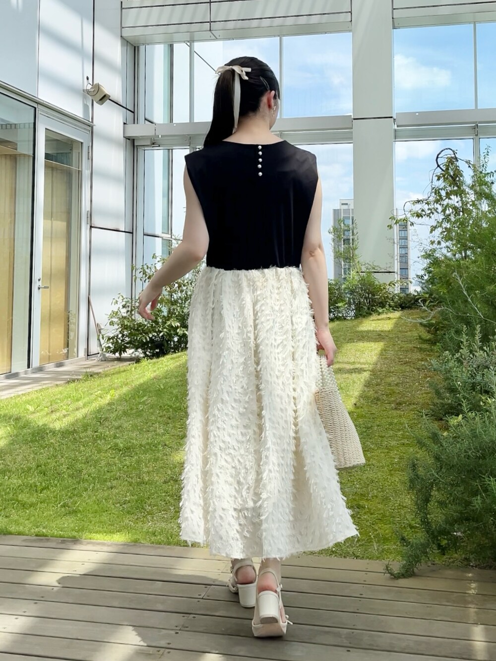 ブラック系のカーディガン/ボレロ、ホワイト系のワンピースを着用したレディースの夏コーディネートの4枚目の写真