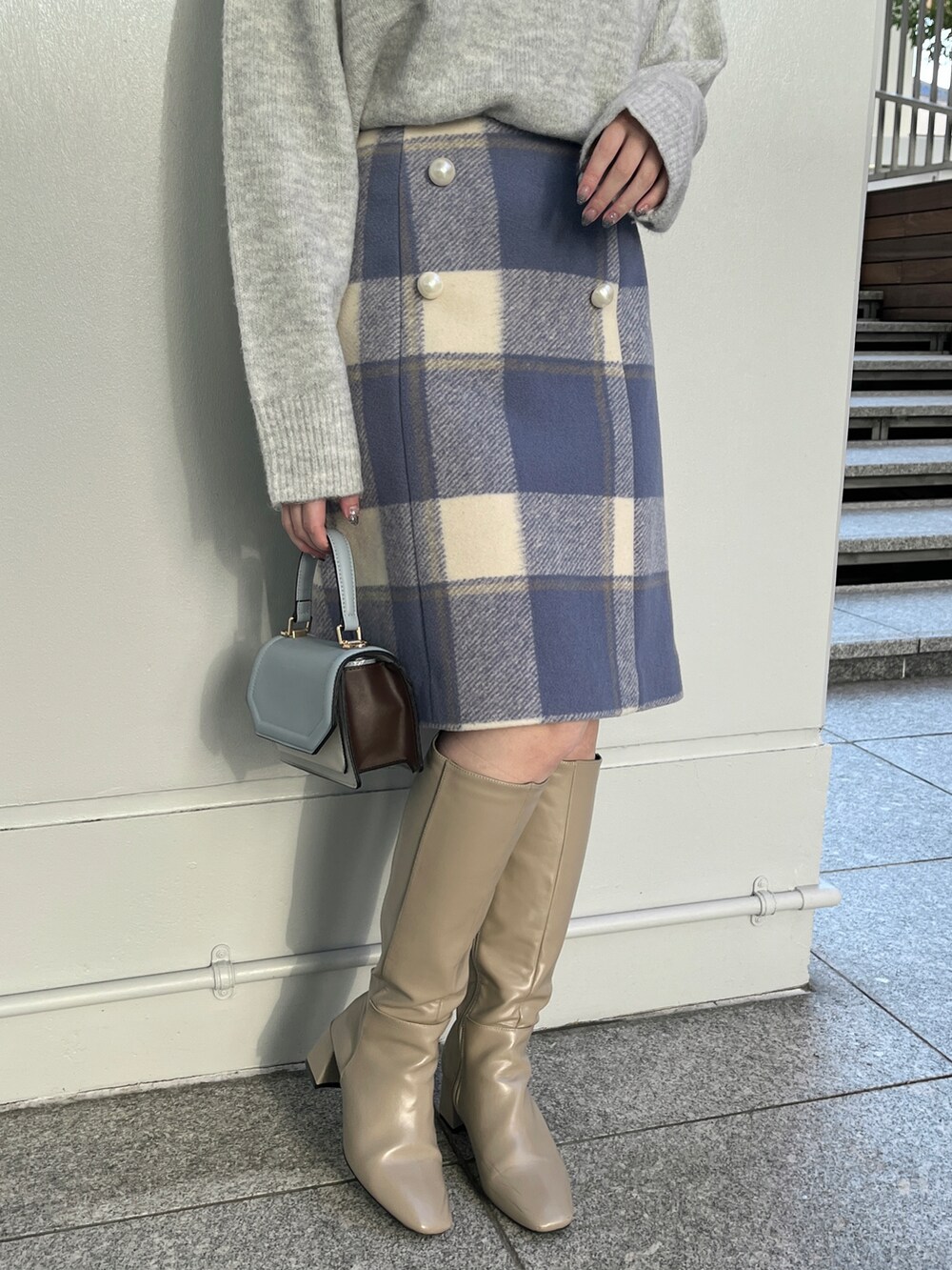 ブルー系のスカート、グレー系のニット/セーター、ベージュ系のブーツを着用したレディースの冬コーディネートの3枚目の写真