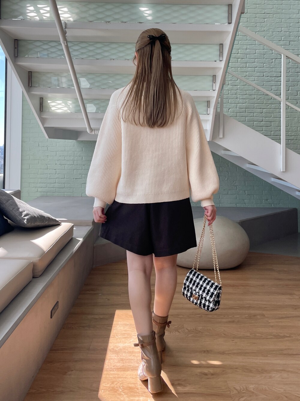 ホワイト系のブルゾン、ホワイト系のニット/セーター、ブラウン系のその他パンツを着用したレディースの秋コーディネートの5枚目の写真