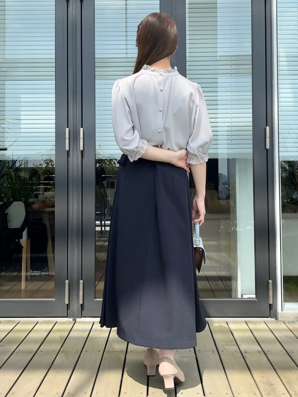 グレー系のシャツ/ブラウス、ブルー系のスカートを着用したレディースの秋コーディネートの3枚目の写真