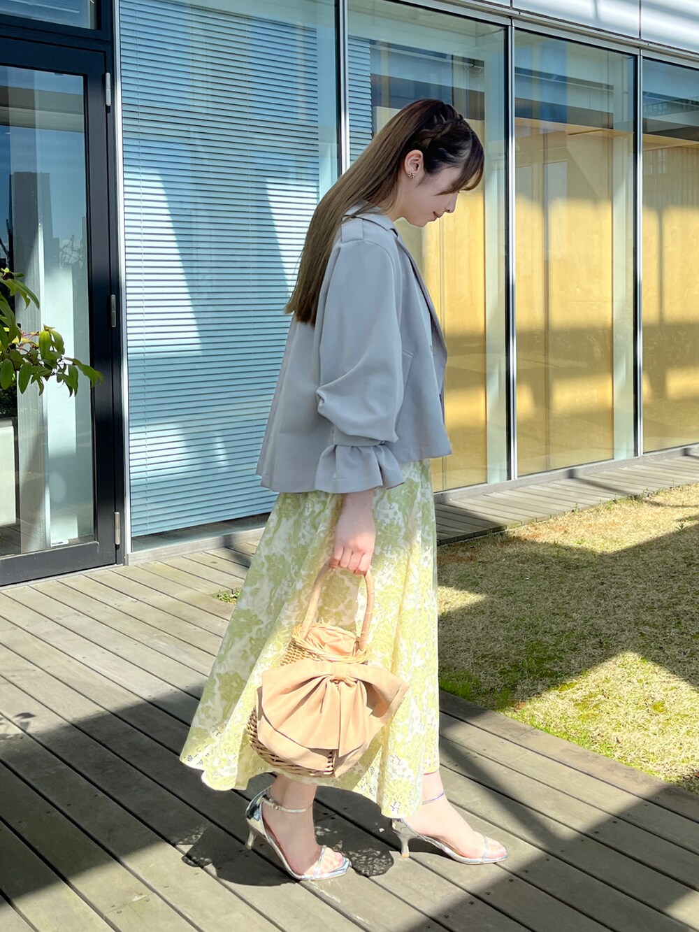 グレー系のトレンチコート、ホワイト系のワンピースを着用したレディースの春コーディネートの2枚目の写真