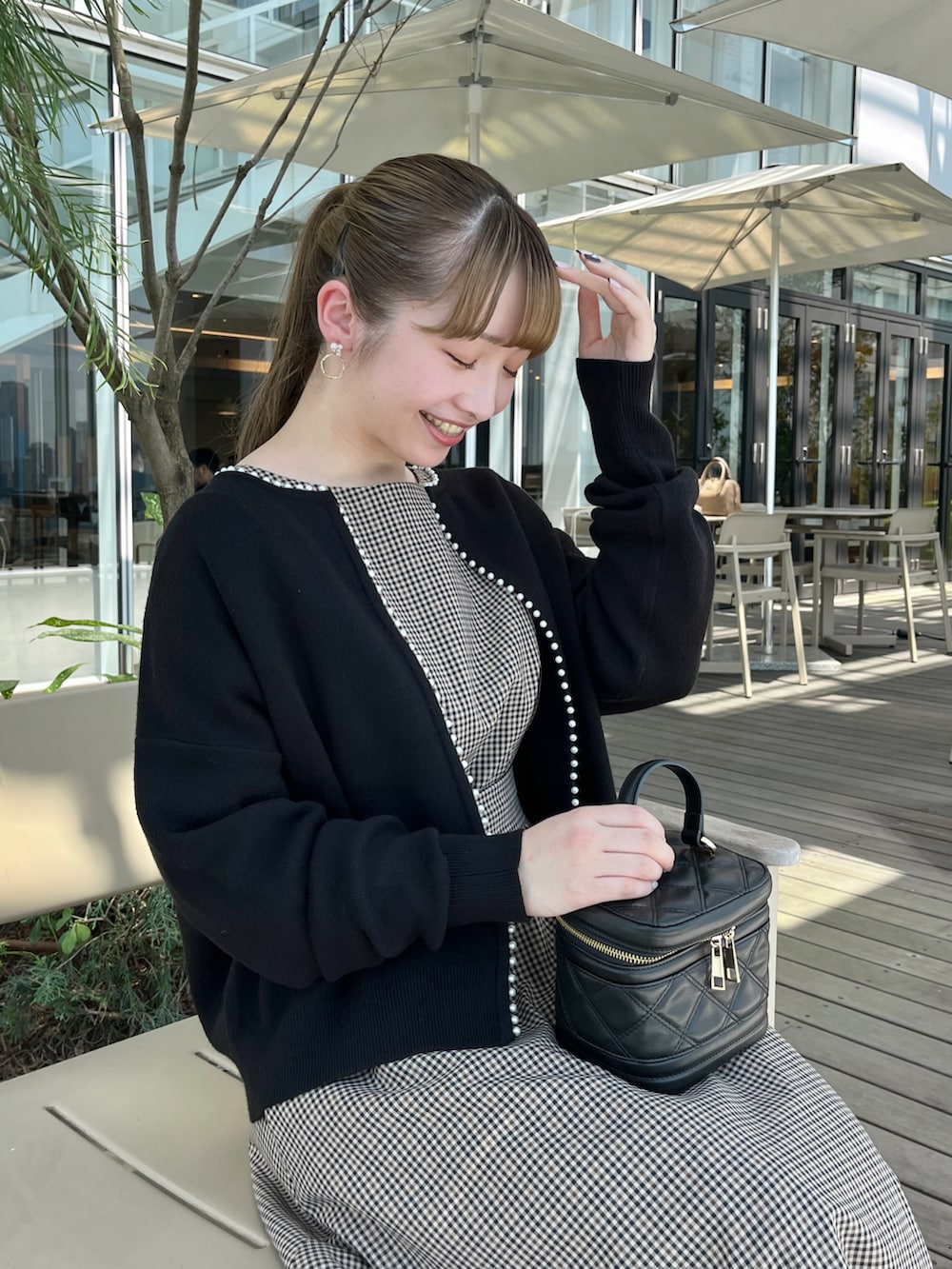 ベージュ系のワンピース、ブラック系のカーディガン/ボレロを着用したレディースの秋コーディネートの4枚目の写真